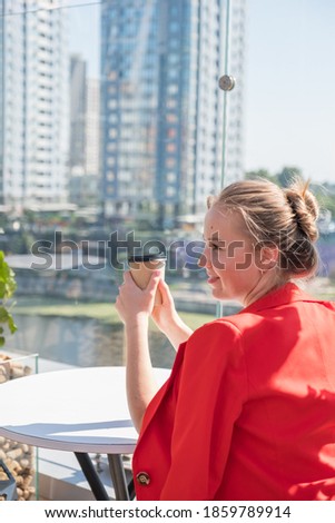 Woman sitting in cafe drinking coffee and planing her agenda. She alone in beautiful place, relaxing and dreaming about future