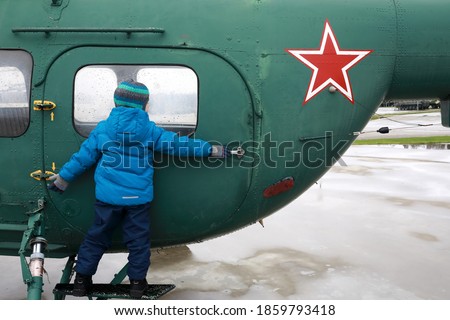 Kid looking out window of military helicopter Hoplite, Russia