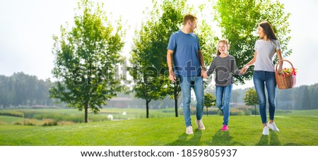 Group portrait of going on picnic young family, countryside or park. Happy childhood and summertime concept image. Copy space empty place for some text. Sunny day picture.