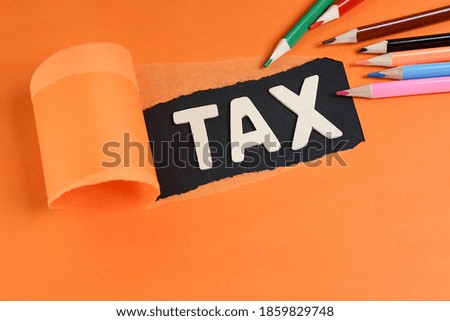 Business concept.  Block letters on tax with torn paper effect and colorful pencils 