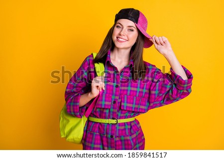 Photo of pretty optimistic teen girl go to college wear pink headwear dress green bag belt isolated on yellow color background