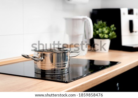 Pot in the kitchen on the induction hob. Induction electrical stove Royalty-Free Stock Photo #1859858476