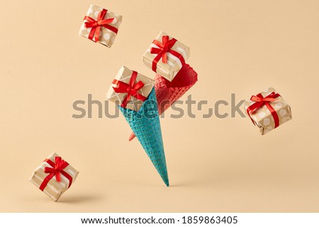 Ice cream cone with falling gift box. Trendy beige background. Minimal creative party concept