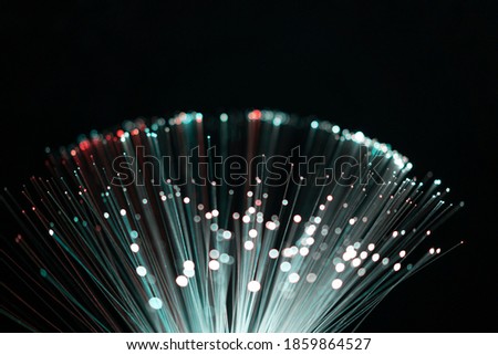 Fiber optic abstract blue, white and green lights colorful background. Close up view with bokeh. Glowing optical fibers. Abstract image with copy space.