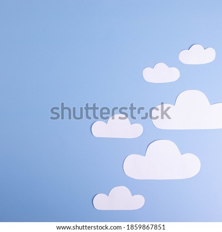 white paper clouds on plain light blue background. cope space