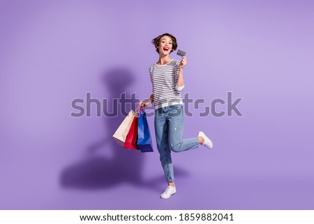 Full length photo of adorable buyer woman wear casual outfit holding colorful shopping bags credit card isolated violet color background