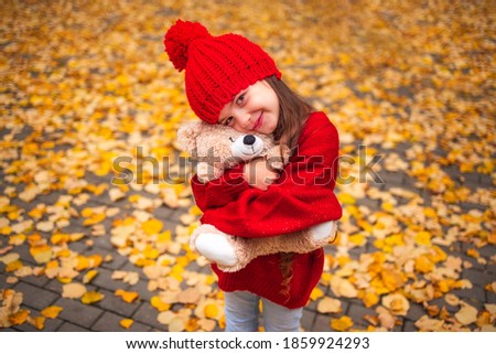 Happy little girl playing with his teddy bear toy in autumnal park Royalty-Free Stock Photo #1859924293