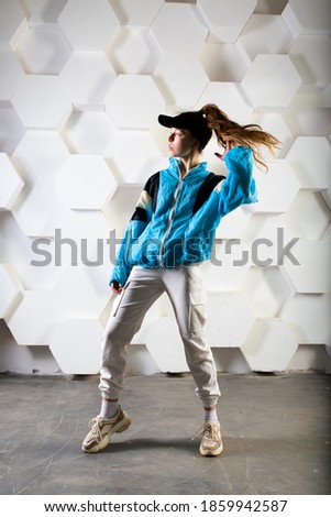 Teenage female dancing hip-hop in a studio, casual clothes