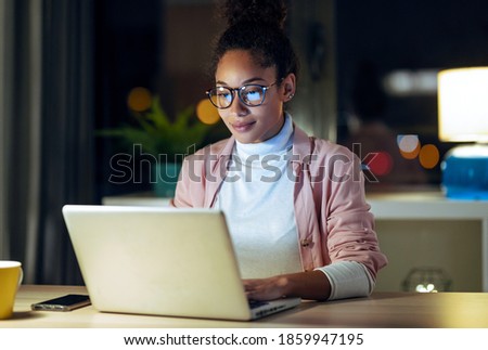 Shot of pretty happy young entrepreneur woman working with laptop sitting in the office. Royalty-Free Stock Photo #1859947195