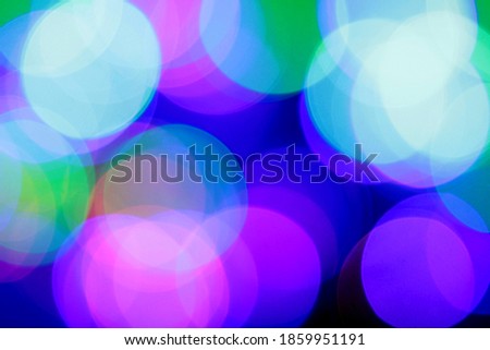 Christmas garland of electric multi-colored light bulbs. Abstract blurred background