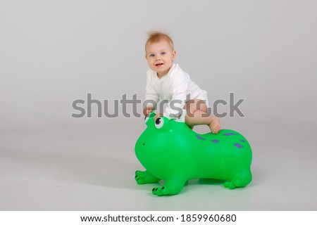 Baby on inflatable horse toy for kids isolated on white background . Rubber pony animal toy for kids. A great toy for balance, strengthening core muscles and fun.

