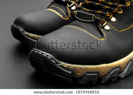 Pair of winter boots on black background. Close up.