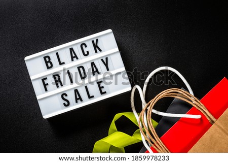 Black friday sale. Lightbox with shopping bags at black background. Top view.