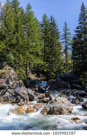 Courmayeur, Aosta Valley, Italy - August 5, 2020: Mountain stream in Val Ferret, on the borders between Italy, France and Switzerland (Mont Blanc massif).