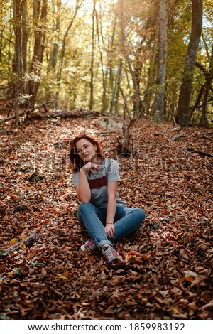 traveler hipster woman standing alone in autumn woods . Cold weather, fall colors. Wanderlust concept.