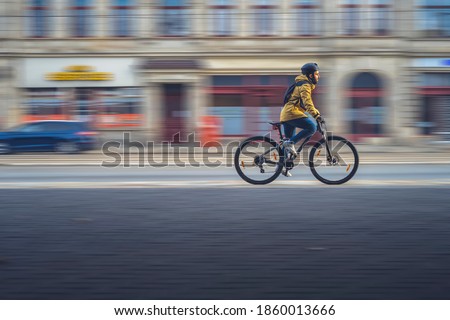 Side view of a boy on a bike, with panning technique. Royalty-Free Stock Photo #1860013666