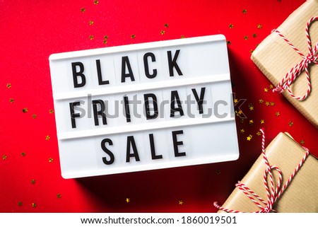 Black friday sale concept with present boxes and lightbox at red background. Top view image.