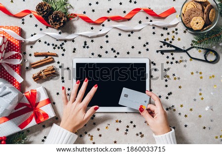 Women shopping Christmas presents online on digital tablet top view