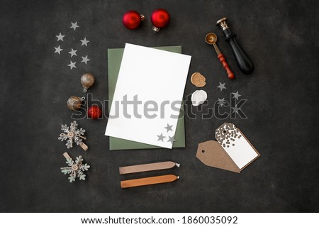 Paper blank for Christmas or New year greeting card stock photo. White paper blank for Christmas or New year, holiday decorations on dark background top view. Flat lay style