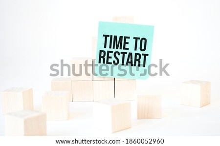 Text Time to Restart writing in green card cube ladder. White background. Business concept