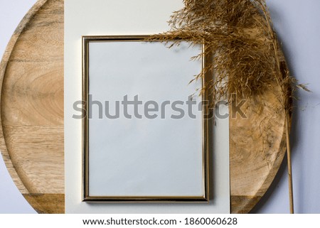 Blank, empty frame mockup on round wooden plate. Dry grass, reed in background. Modern template. Branding identity. Natural autumn, fall design. Flat lay, top view