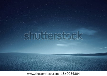 Starry christmas night. Dark sky full of stars. Monochrome picture of winter night. Field covered with snow. Christmas background.