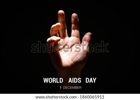 Hand reaching upwards with open palm on black isolated background. First december World AIDS Day Cancer Control concept Symbolizing day of AIDS and HIV. Concept of Hope and Support.