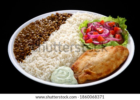 Traditional lunch dish in Ecuador consisting of chicken breast, rice, lentils, salad and a small portion of tartar sauce. Royalty-Free Stock Photo #1860068371