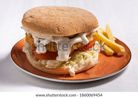 Chicken burger with french fries on white board