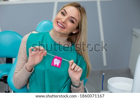 Portrait of the beautiful woman sitting in the dental chair, smiling after successful treatment. 