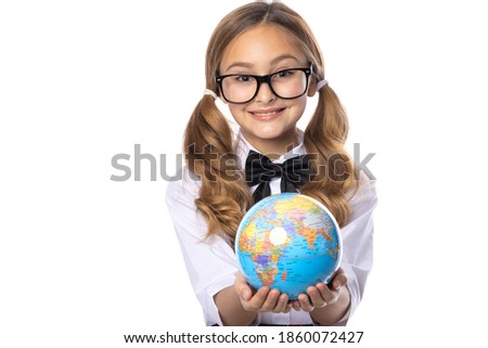 Schoolgirl girl in glasses, holding a globe in her hands, isolated on a white background.
