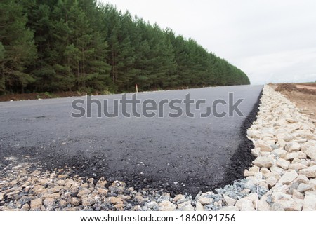 Construction of a new road. Fresh asphalt laying. The beginning of the road