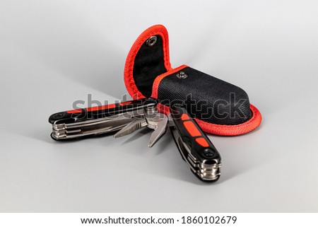 Multipurpose Tool - Multipurpose pliers, knife, screwdriver, hook, saw on a neutral background - Isolated Royalty-Free Stock Photo #1860102679