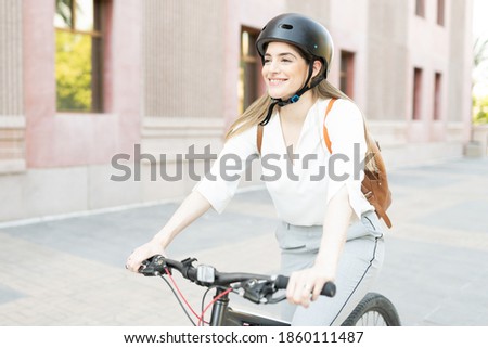 Woman with an active and fitness lifestyle choosing to use a green and eco-friendly bike in her commute to work 