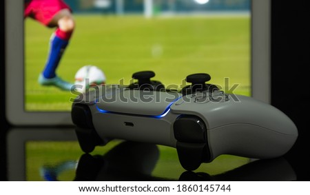 Next Gen game controller with football game at screen Royalty-Free Stock Photo #1860145744