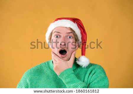 Young handsome man wearing santa claus hat. Funny face. Male portrait. Christmas time. Happy New Years.