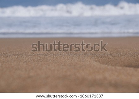 A picture of sand and ocean water from low level point of view