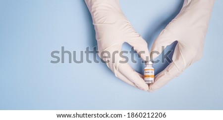 Doctor's Hands in medical latex gloves holding Coronavirus 2019-nCoV Vaccine vial and gesture in heart shape. Successful, Hope, Good news, Support, Donation, Priority, Fight with Covid-19 pandemic. Royalty-Free Stock Photo #1860212206