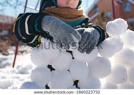 Boy playing snowballs. Child with snowballs. Children's winter games. Close up