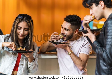 group of friends dining tacos at night in a street business Royalty-Free Stock Photo #1860258229