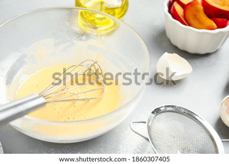 Dough and ingredients for cake on light grey table, closeup