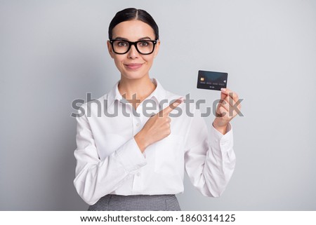 Photo of promoter lady direct forefinger debit card wear eyeglasses white shirt isolated grey color background