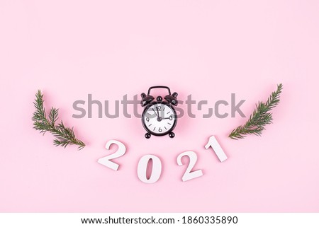 Wodden 2021 Creativity ideas concepts with little clock on pink color background. New years content. Flat lay