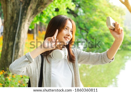 Young girl taking selfie photo during her trip to Hanoi
