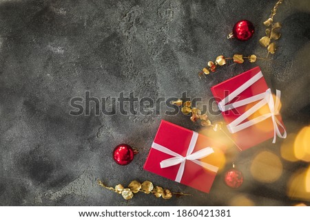 Christmas composition with golden branches, gifts, decoration and lights with bokeh on dark background. Flat lay, top view