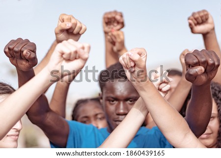 People raised fist air fighting for their rights. Labor movement, election movement, no racism, no lockdown,  no coronavirus (covid 19), deniers and union concept. Focus on black fist or hand. Royalty-Free Stock Photo #1860439165