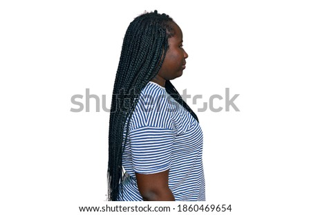 Young black woman with braids wearing casual clothes looking to side, relax profile pose with natural face with confident smile. 