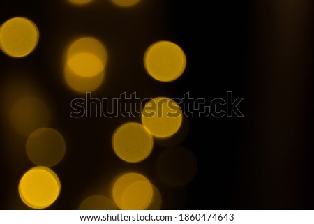 Blurred sparks from fire in front of black backgound. Christmas and New Year holidays concept.  Defocused garland lights, Bokeh effect. 