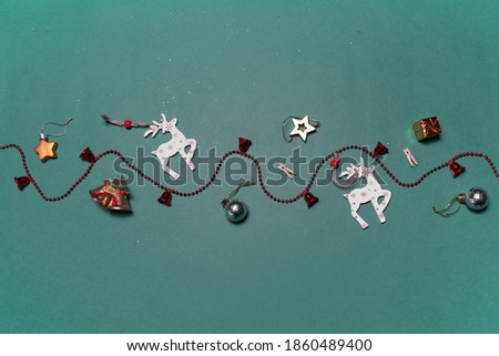 Christmas background with decorative toys of deers and gifts on green background.