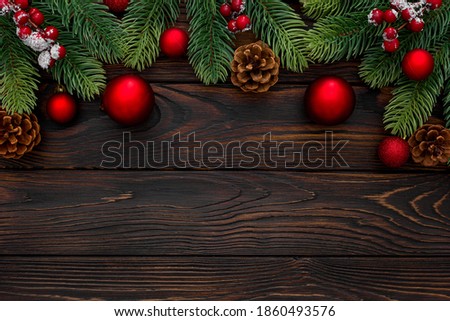 Spruce branch, cones and toys decoration on christmas or new year on dark wooden background
